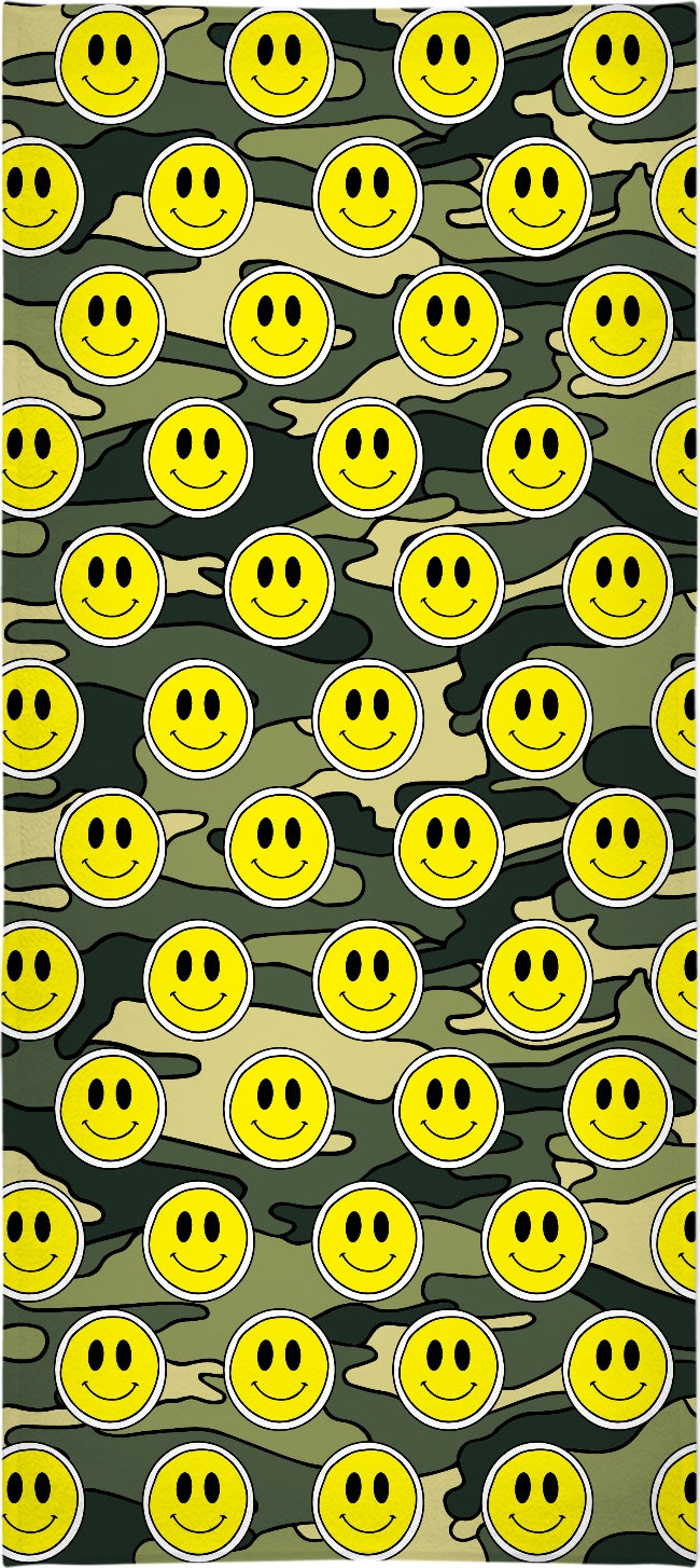 A towel with a green camouflage pattern and smiley face designs on it.