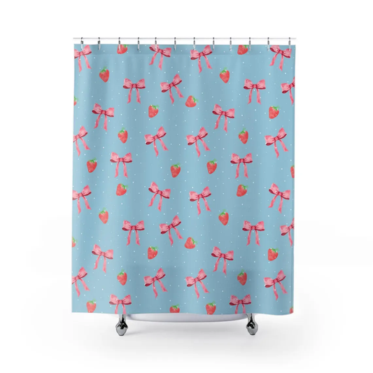 A shower curtain with a pattern of strawberries and pink bows on a blue background.